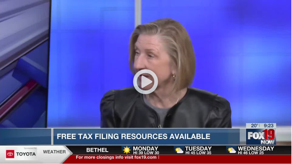 A news broadcast screenshot from FOX19 NOW featuring a woman with short blonde hair wearing a black leather jacket. She is speaking in front of a blue studio background. A banner at the bottom of the screen reads "FREE TAX FILING RESOURCES AVAILABLE." The lower section also displays a weather forecast and sponsor logos, with temperatures for upcoming days and a mention of more closings at fox19.com.